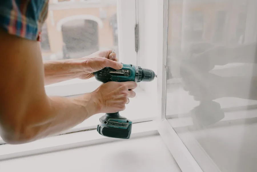 Adjusting a window frame with a cordless drill